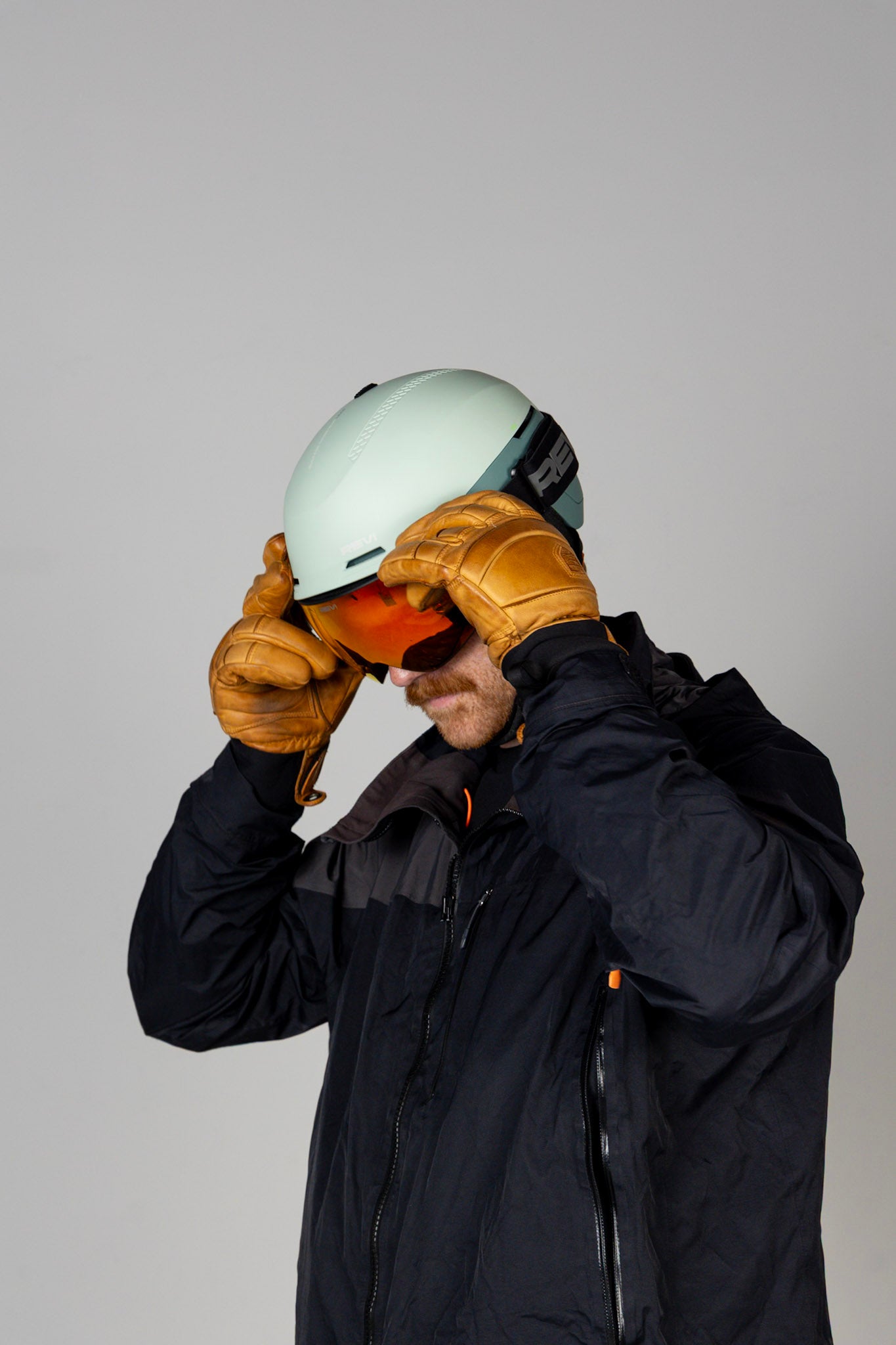 Person wearing a helmet and goggles, standing against a plain background